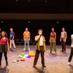ROKOK88 super actors rehearsing a modern play backstage in vibrant theatre atmosphere.